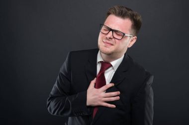 İş adamı gibi hurtin kalp tutan siyah takım elbise giyen