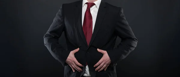 Hombre de negocios con traje negro sosteniendo el vientre como herido —  Fotos de Stock