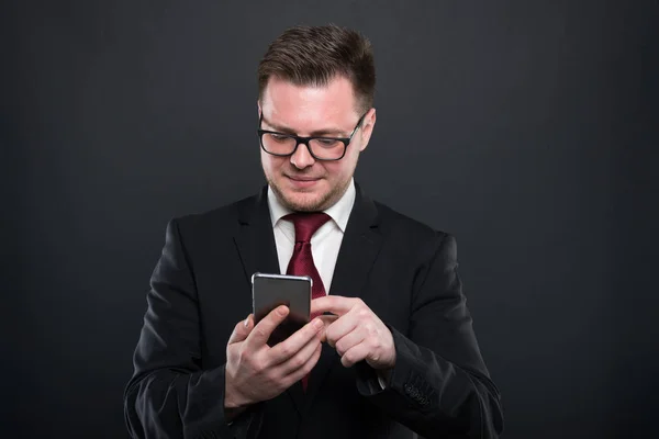 Negócios jovem navegando no smartphon preto — Fotografia de Stock