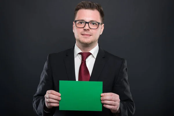 Ritratto di uomo d'affari con cartoncino verde in mano — Foto Stock