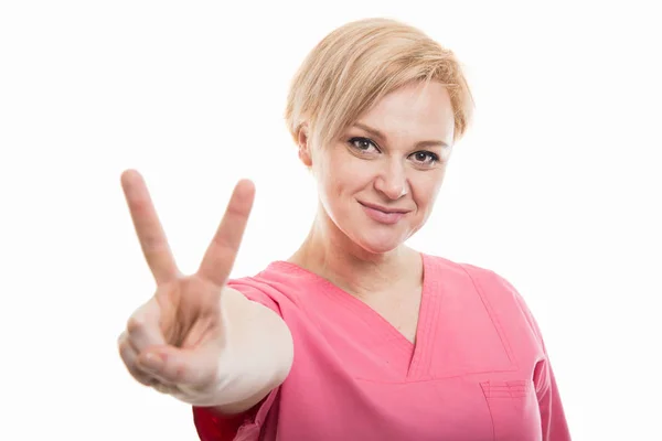 Attraente infermiera che indossa scrub rosa mostrando gestur pace — Foto Stock