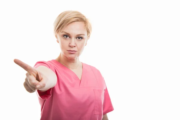 Atractiva enfermera vestida con uniformes rosados que muestran negación —  Fotos de Stock
