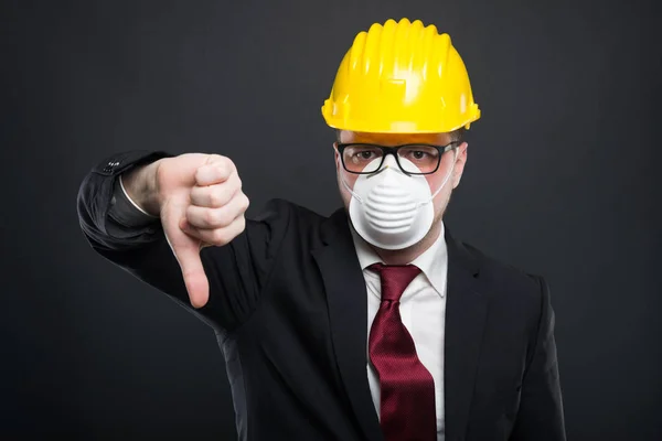 Affärsman som bär hardhat och mask visar dislik — Stockfoto