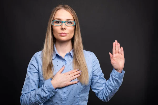 Senhora de negócios vestindo óculos azuis fazendo juramento gestur — Fotografia de Stock
