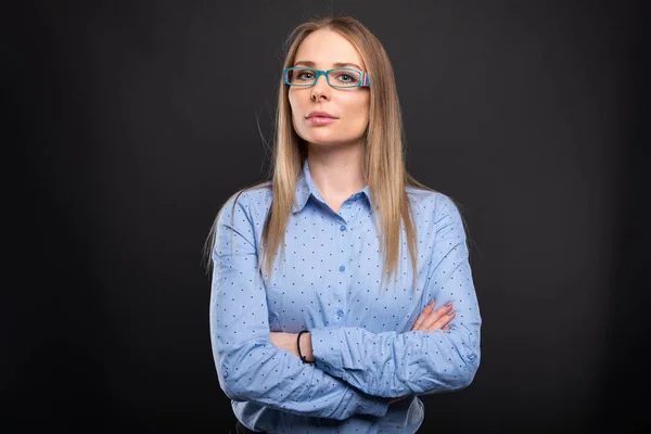 Mujer de negocios con gafas azules de pie con los brazos cruzados —  Fotos de Stock