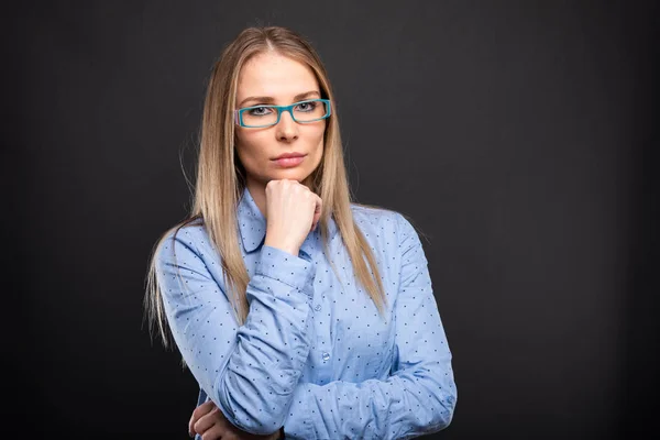 Mujer de negocios con gafas azules posando con la mano en chi —  Fotos de Stock