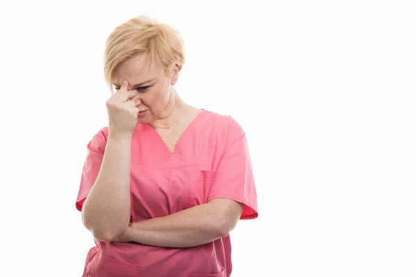 Enfermeira feminina vestindo esfoliação rosa em pé e concentrando — Fotografia de Stock