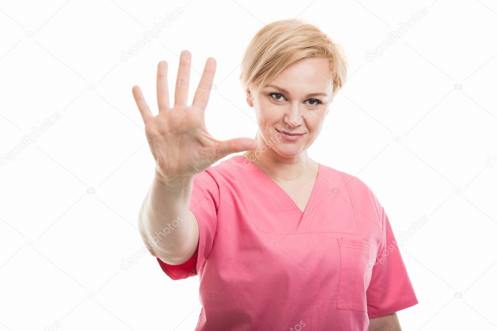 Attractive female nurse wearing pink scrubs showing number five