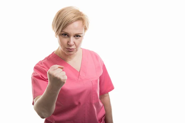 Привлекательная медсестра в розовом халате с кулаком — стоковое фото