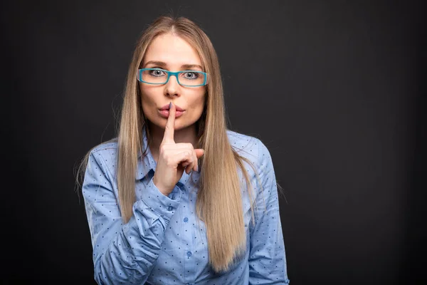 Geschäftsfrau mit blauer Brille zeigt Schweigegegeste — Stockfoto