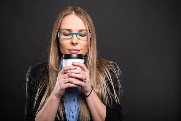 Mujer de negocios con gafas azules oliendo café a g —  Fotos de Stock