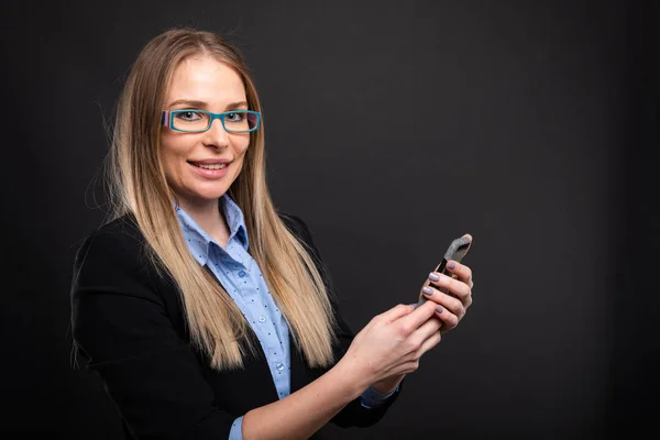 Mujer de negocios con gafas azules sosteniendo smartphon —  Fotos de Stock