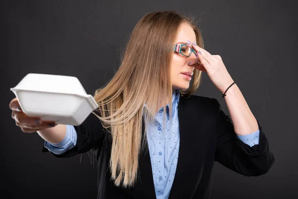 Business lady wearing blue glasses holding bad smelling lunch bo — Stock Photo, Image