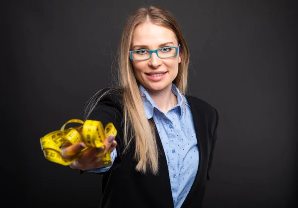 Business lady wearing blue glasses holding measuring tap — Stock Photo, Image