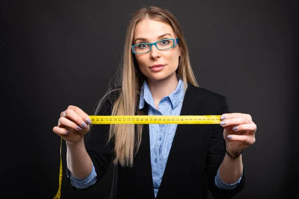 Señora de negocios con gafas azules sosteniendo grifo de medición —  Fotos de Stock