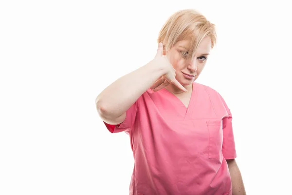 Atractiva enfermera vistiendo bata rosa haciendo teléfono ges —  Fotos de Stock