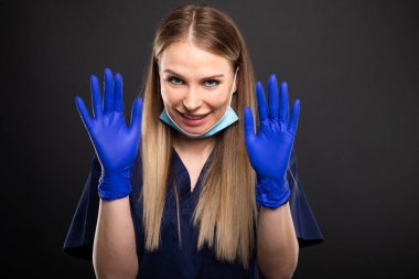 Güzel kadın dişçi yüz maskesi gösteren eldiven