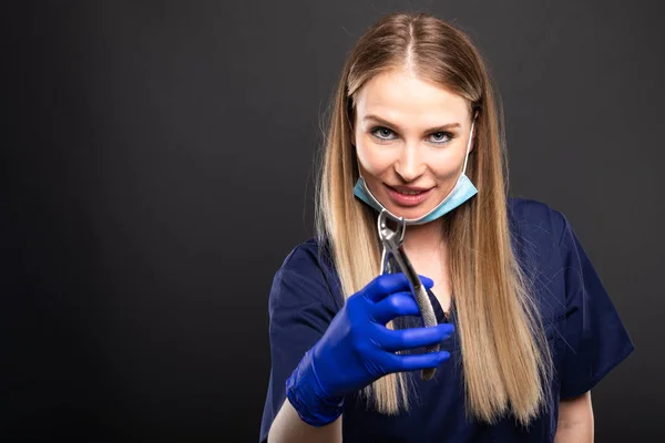 Schöne Zahnärztin mit Gesichtsmaske hält cla — Stockfoto