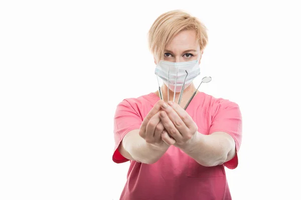 Attraktiva kvinnliga tandläkare bär scrubs visar verktyg — Stockfoto