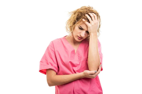 Portrait of nurse wearing pink scrub holding head like hurting — Stock Photo, Image