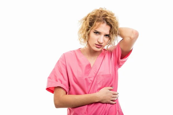 Portrait of nurse wearing pink scrub holding back head like hurt — Stock Photo, Image