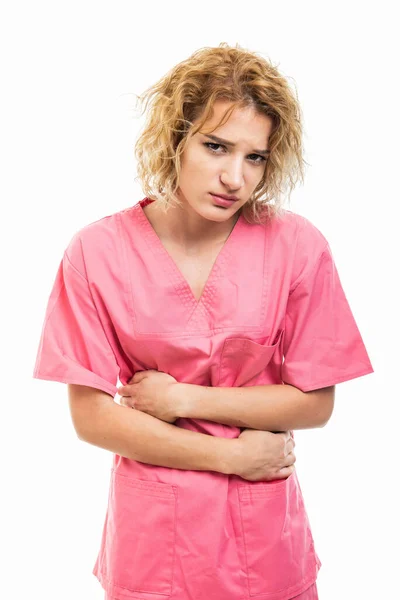 Portret pielęgniarki noszącej różowy peeling trzymającej brzuch jak ból — Zdjęcie stockowe
