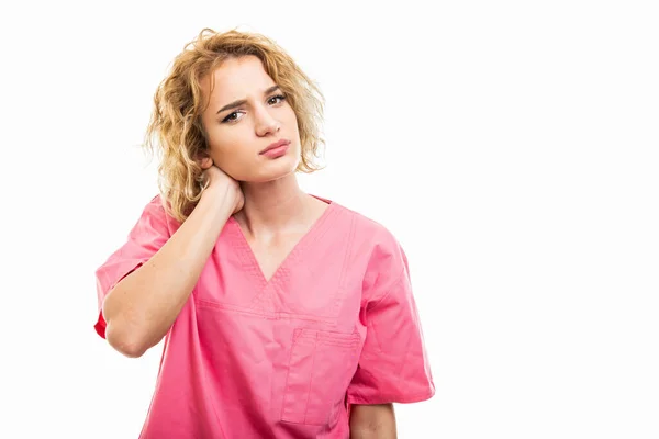 Retrato de la enfermera con un exfoliante rosa sosteniendo el cuello como herido —  Fotos de Stock