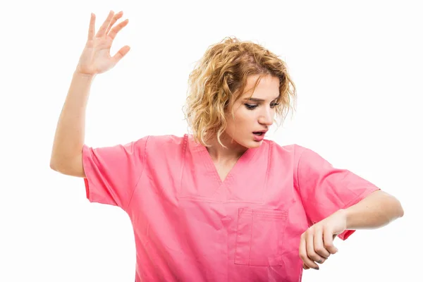 Portrait of nurse wearing pink scrubs making late gesture — 图库照片