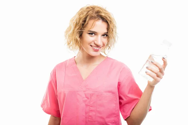 Portrait of nurse wearing pink scrub holding bottle of water — 图库照片
