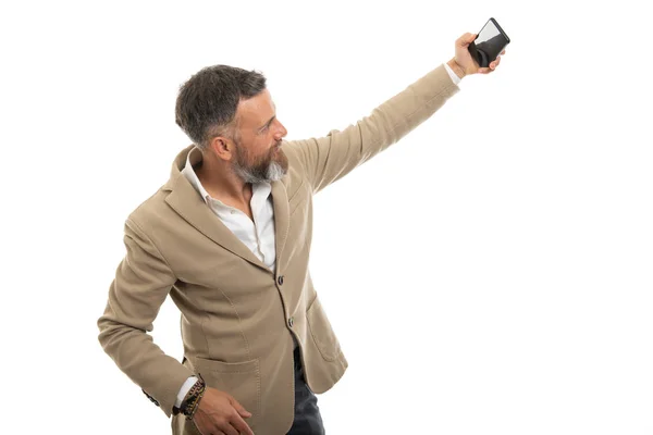スマートなカジュアル服を身に着けている男は白い背景に隔離されたスマートフォンで自撮り — ストック写真