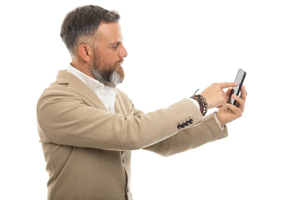 白い背景に隔離されたスマートフォンにタッチスクリーンを使用してスマートカジュアル服を身に着けている男 — ストック写真