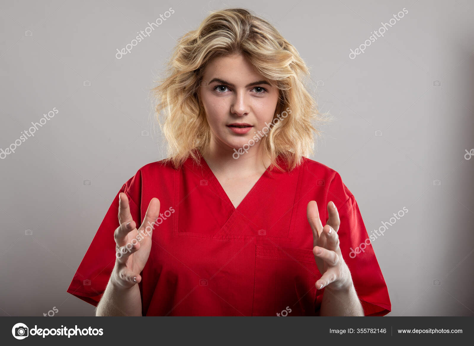 Portrait of female nurse wearing red scrub writing with marker on studio  gray background with copy space advertising area Stock Photo - Alamy