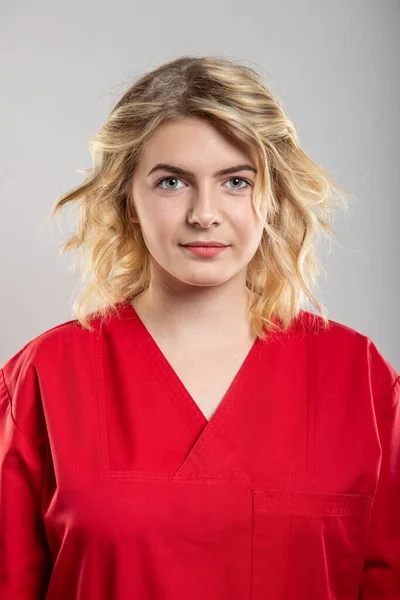 Portret Femeie Tânără Asistentă Medicală Purtând Scrub Roșu Fundal Gri — Fotografie, imagine de stoc