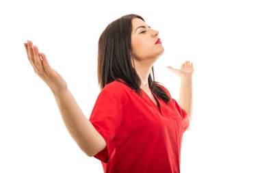 Önlük giyen güzel genç doktorun portresi, beyaz arka planda izole edilmiş, fotokopi alanı reklam alanı olan kazanan jesti gösteriyor.