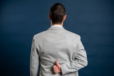 İş dünyasının arka planında genç bir erkeğin mavi arka planda el hareketi yapması.