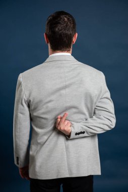 Genç bir erkeğin mavi arka planda müstehcen davranışlar sergilemesi.