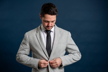 İş portresi mavi arka planda genç yakışıklı erkek düğme ceketi ve fotokopi alanı reklam alanı