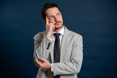 İş portresi genç yakışıklı erkek düşünme jesti mavi arka planda fotokopi alanı reklam alanı ile