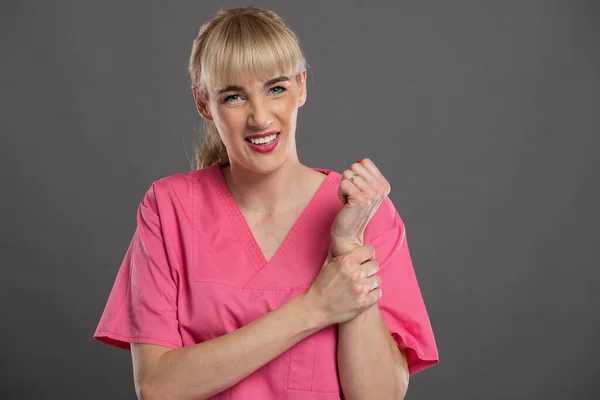 Retrato Jovem Enfermeira Atraente Segurando Pulso Como Ferir Fundo Cinza — Fotografia de Stock