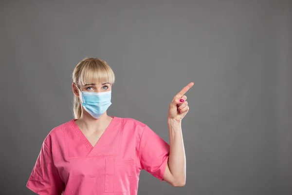 Portrait Young Attractive Female Nurse Pointing Face Mask Showing Copy — Stock Photo, Image