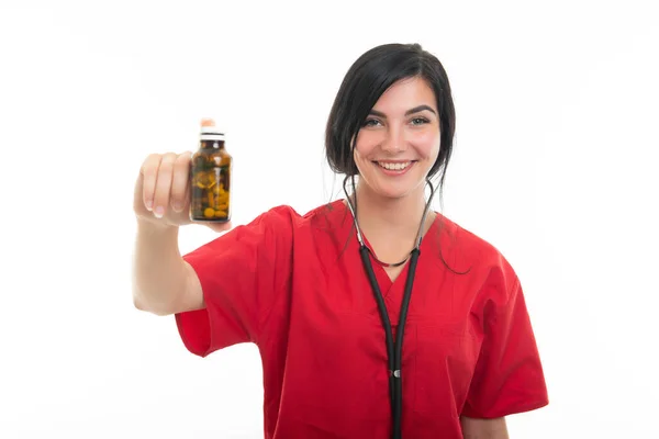 コピースペース広告領域と白地に隔離された錠剤のボトルを示す若い魅力的な女性看護師の肖像 — ストック写真