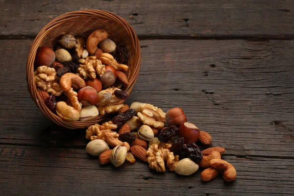 Змішайте смачні горіхи в мисці, на дерев'яному фоні — стокове фото