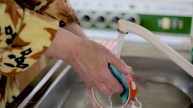 Sarı ceketli kız Coronavirus sırasında ellerini sabunla iyice yıkıyor. Yakın plan.