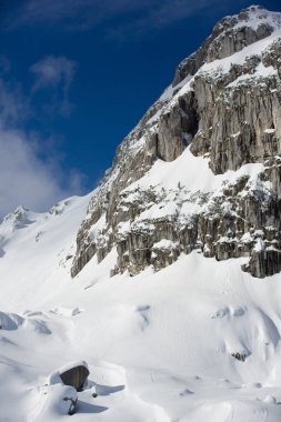 Mavi gökyüzü, manzara ile kayalık dağ kar kaplı