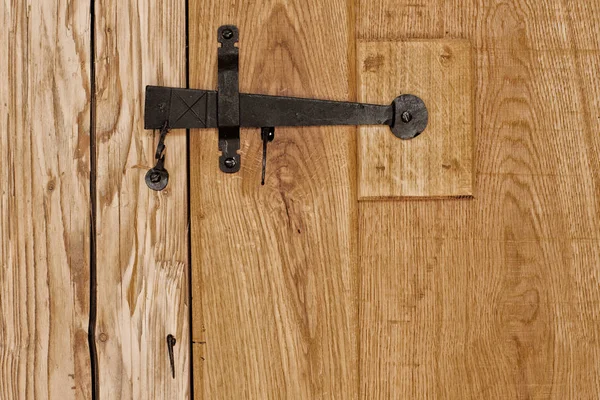 Rustic wooden door with hammered old fashioned iron lock — Stock Photo, Image