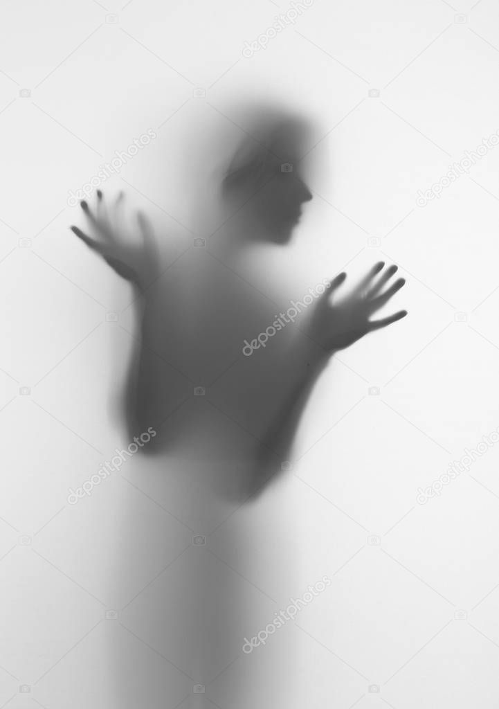 Woman silhouette of face and hands behind a diffuse surface