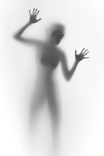 Femme impressionnée derrière un mur de verre, crie. Visage, silhouette, mains . — Photo