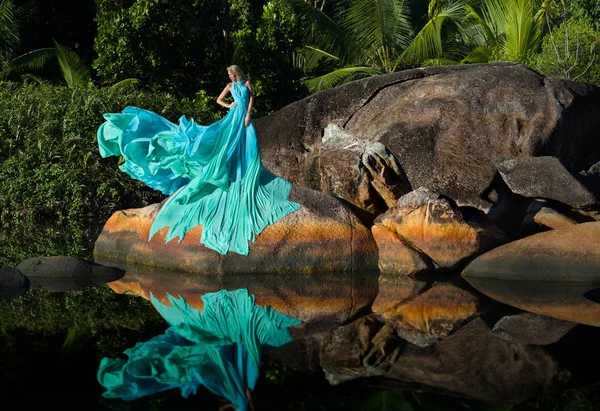 Mulher loira em vestido longo extremo em rochas de Seychelles — Fotografia de Stock