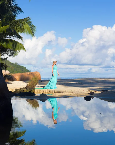 Blonde woman in turquoise long dress at the beach, Seychelles — Stock Photo, Image