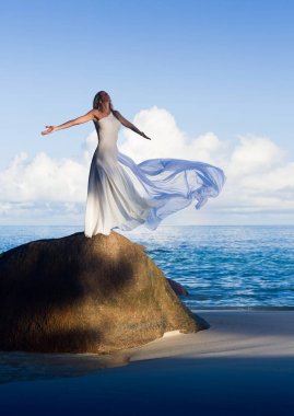 Beyaz elbise kumlu plajda uçan güzel ince kadın